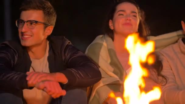Gece kamp ateşinde oturan arkadaş grubu — Stok video