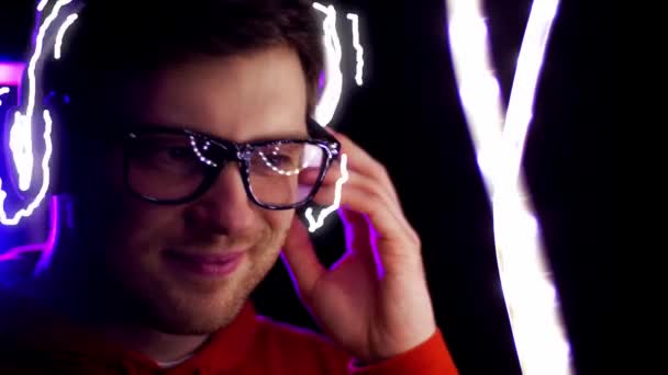 Man in headphones over neon lights of night club — Stock Video