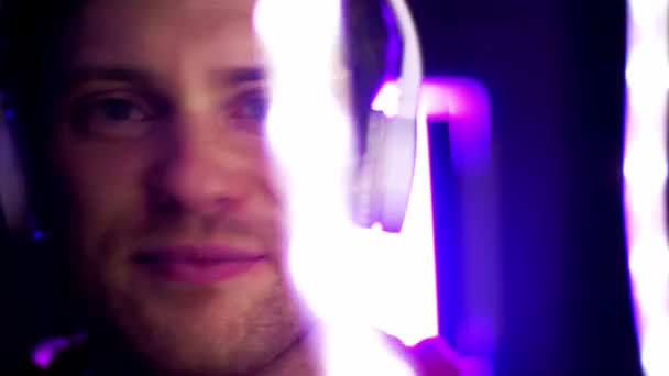 Hombre en auriculares sobre luces de neón del club nocturno — Vídeo de stock