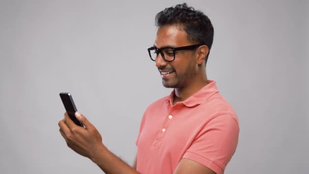 Happy indian man in glasses using smartphone — Stock Video