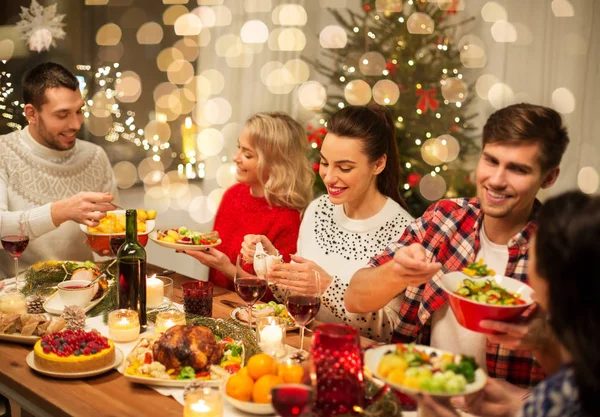 Šťastní přátelé mají vánoční večeři doma — Stock fotografie