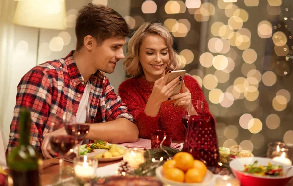 Casal com smartphone em casa jantar de Natal — Fotografia de Stock
