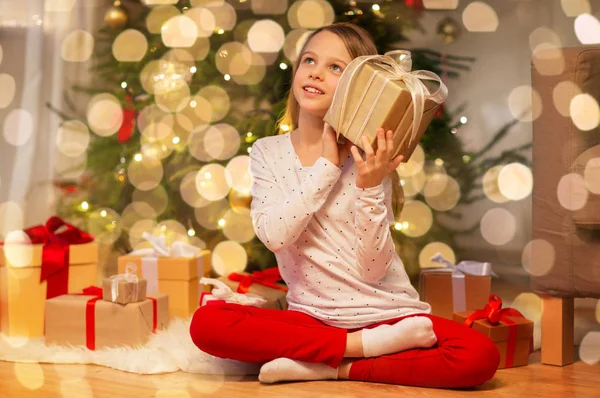 Lächelndes Mädchen mit Weihnachtsgeschenk zu Hause — Stockfoto