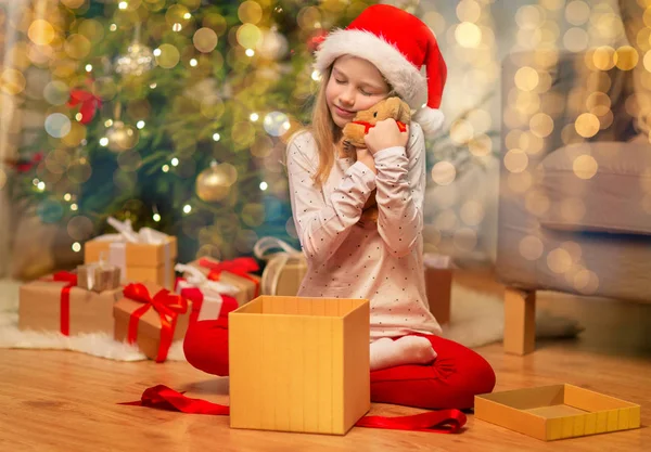 Leende flicka i tomte hatt med julklapp — Stockfoto