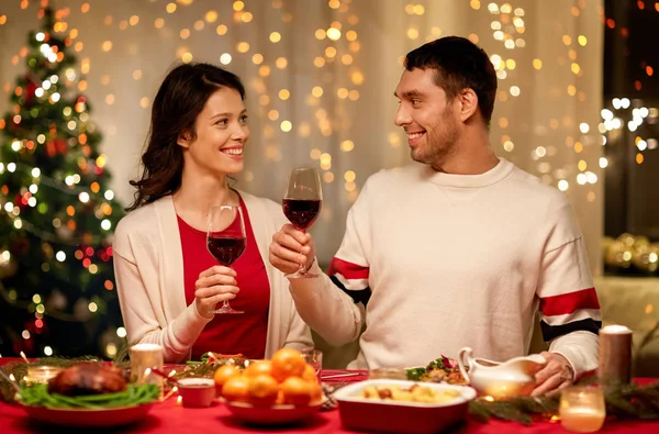 Glada par dricker rött vin till jul middag — Stockfoto