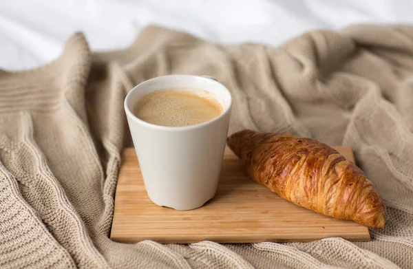 Tasse de café et croissant sur lit ou couverture — Photo