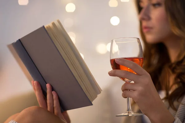 Close up of woman reading book and drinking wine — Stock Photo, Image