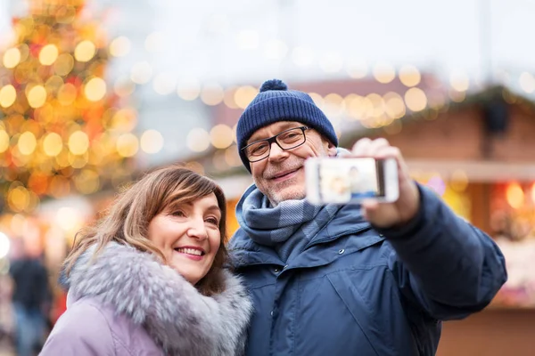 Couple de personnes âgées prenant selfie au marché de Noël — Photo