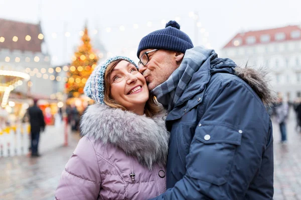 Heureux couple de personnes âgées embrasser au marché de Noël — Photo