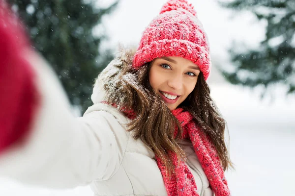 Усміхнена жінка бере селфі на відкритому повітрі взимку — стокове фото
