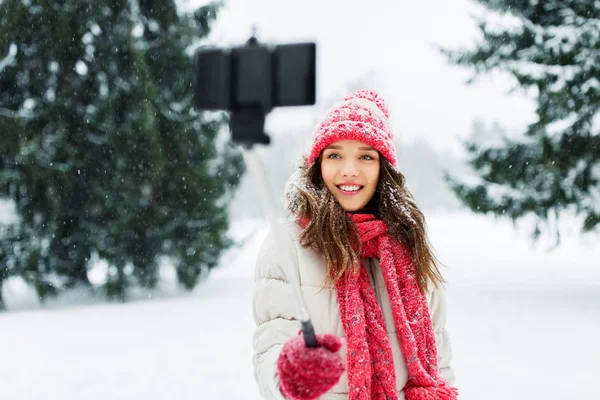 Jovem mulher tomando selfie por monopod no inverno — Fotografia de Stock