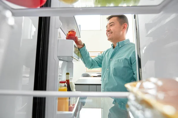 Homme prenant du jus de réfrigérateur à la maison cuisine — Photo