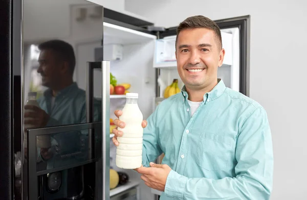 Hombre tomando leche de la nevera en casa cocina —  Fotos de Stock