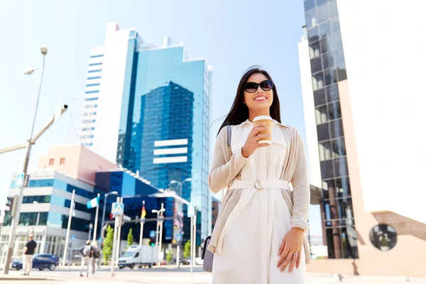 Lächelnde Frau mit Kaffeetasse zum Mitnehmen in der Stadt — Stockfoto