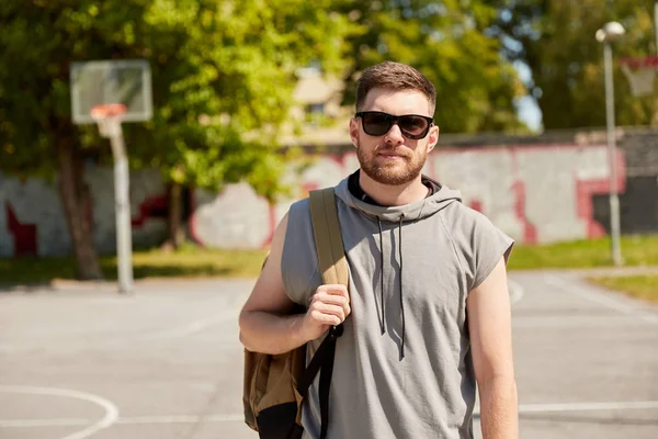 Mężczyzna z plecakiem na placu zabaw koszykówki ulicznej — Zdjęcie stockowe