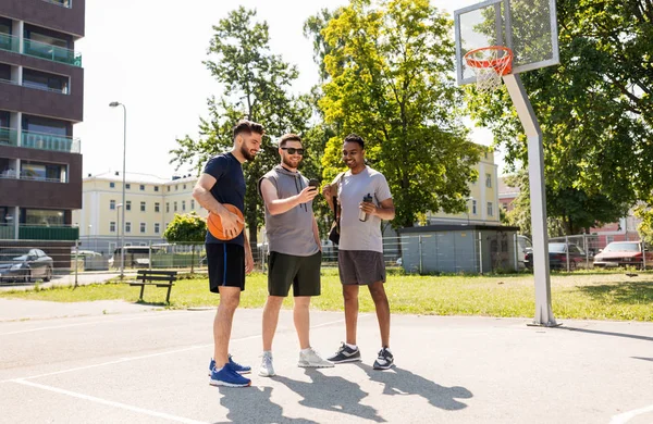 Men with smartphone at basketball playground — Stok fotoğraf