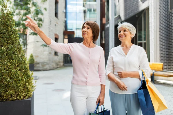 Senior kvinnor med shoppingväskor Walking in City — Stockfoto