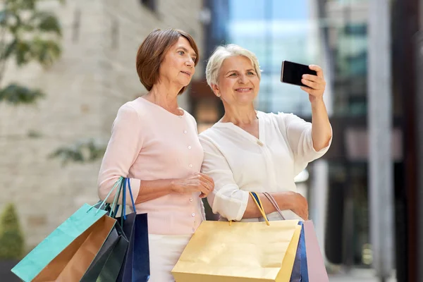 Gamla kvinnor med shoppingväskor tar Selfie i City — Stockfoto
