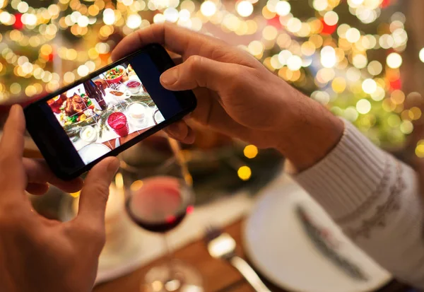 Händer fotografera mat vid jul middag — Stockfoto