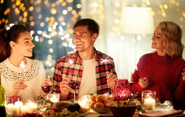 Happy friends celebrating christmas at home feast — Stock Photo, Image