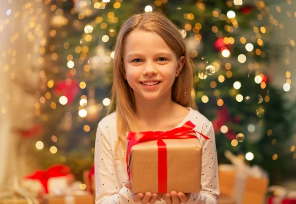 Lächelndes Mädchen mit Weihnachtsgeschenk zu Hause — Stockfoto
