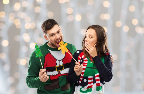 Couple with christmas party props in ugly sweaters — Stock Photo, Image