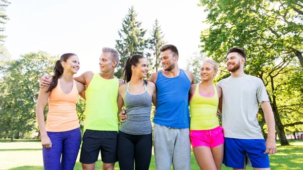 Grupp glada vänner eller idrottsmän på sommarparken — Stockfoto