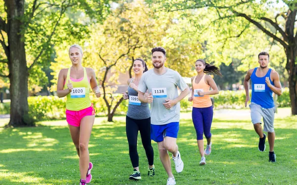 Feliz joven deportistas carreras ingenio insignia números — Foto de Stock