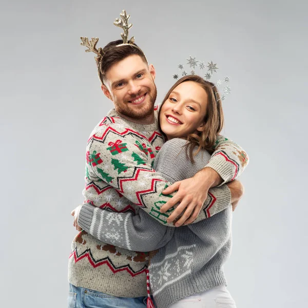 Счастливая пара на рождественской вечеринке уродливых свитеров — стоковое фото