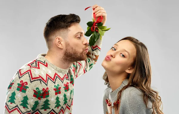 Happy couple kissing under the mistletoe — Stock Photo, Image
