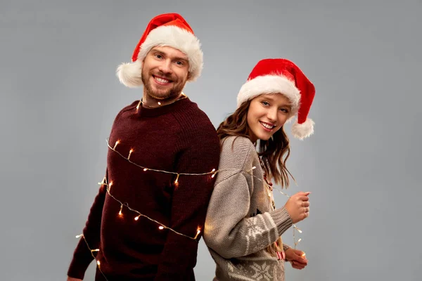 Felice coppia in maglioni di Natale e cappelli di Babbo Natale — Foto Stock