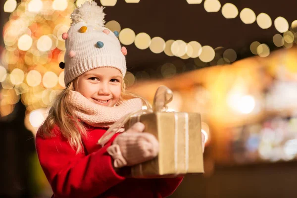 Fille heureuse avec boîte cadeau au marché de Noël — Photo