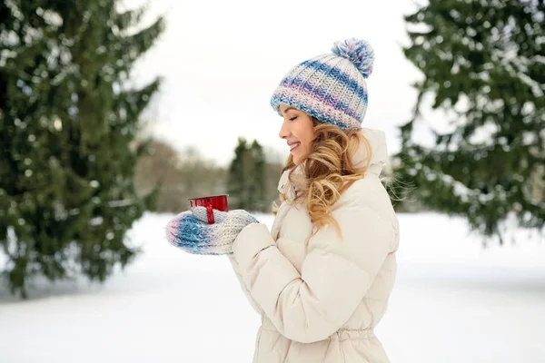 Gelukkig jong vrouw met thee kopje buiten in de winter — Stockfoto