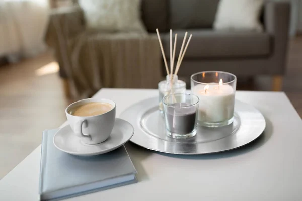 Café, velas y difusor de caña de aroma en la mesa — Foto de Stock