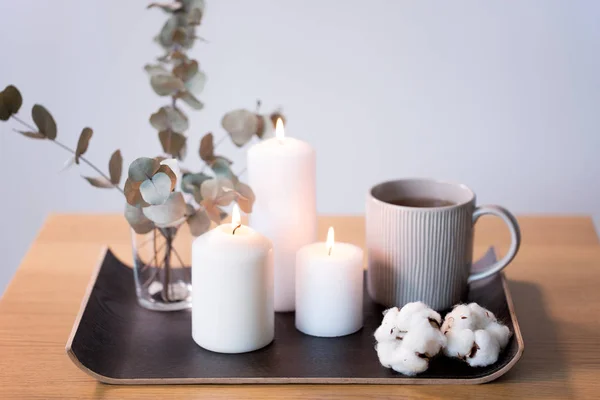 Candles, tea and branches of eucalyptus on table — Stock Photo, Image