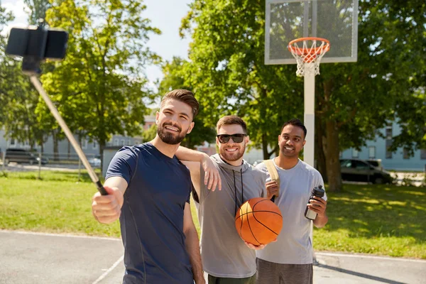 Hommes heureux prenant selfie sur terrain de basket-ball — Photo