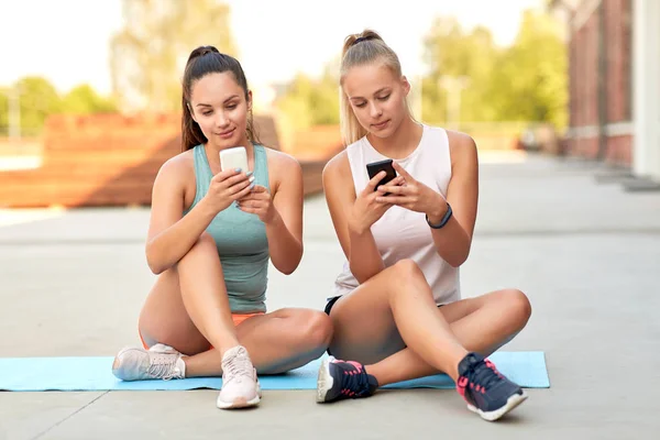 Mujeres deportivas o amigos con teléfono inteligente en la azotea —  Fotos de Stock