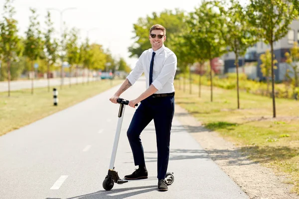 Jeune homme d'affaires équitation scooter électrique en ville — Photo