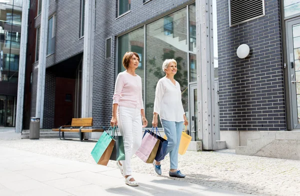 Mulheres idosas com sacos de compras andando na cidade — Fotografia de Stock