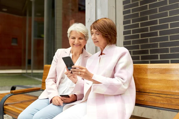 Happy senior women with smartphones in city — Stock Photo, Image