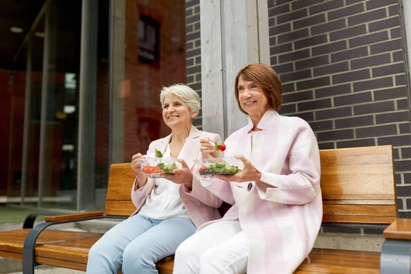 Mujeres mayores comiendo comida para llevar en la calle de la ciudad — Foto de Stock