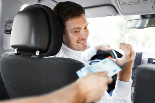Mannelijke auto bestuurder het nemen van geld van de passagier — Stockfoto