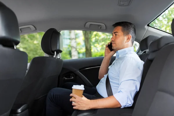 Affärsman med kaffe ringer på telefon i bilen — Stockfoto