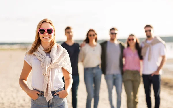 Mujer feliz con amigos en la playa en verano —  Fotos de Stock