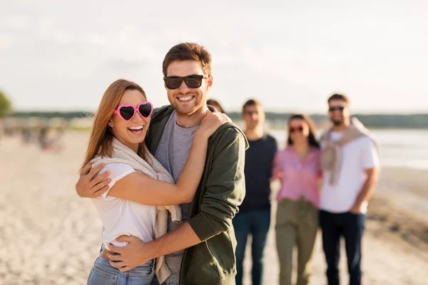 Glada vänner promenader längs sommarstranden — Stockfoto