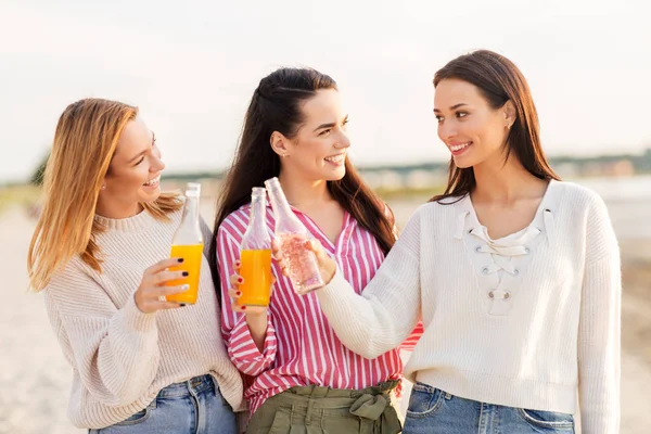 Mulheres jovens brindando bebidas não alcoólicas na praia — Fotografia de Stock