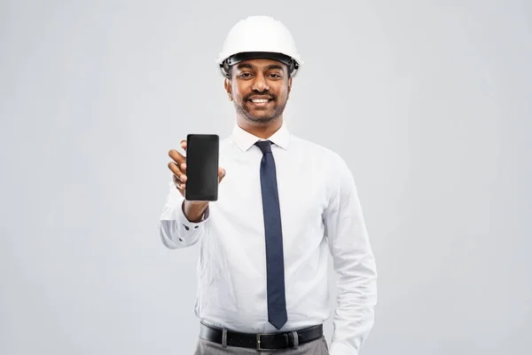 Arquitecto indio masculino en casco mostrando smartphone — Foto de Stock