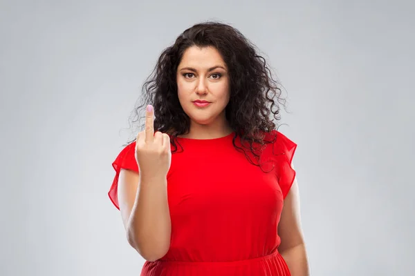 Mujer ignorante en vestido rojo mostrando el dedo medio — Foto de Stock