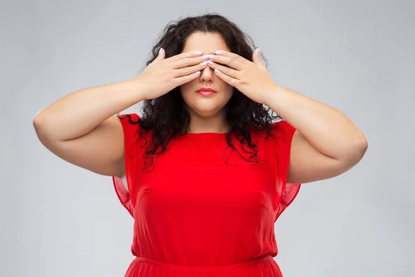 Donna in abito rosso chiudendo gli occhi per mano — Foto Stock