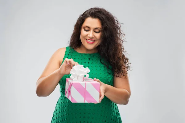 Ευτυχισμένη γυναίκα σε πράσινο φόρεμα άνοιγμα κουτί δώρου — Φωτογραφία Αρχείου